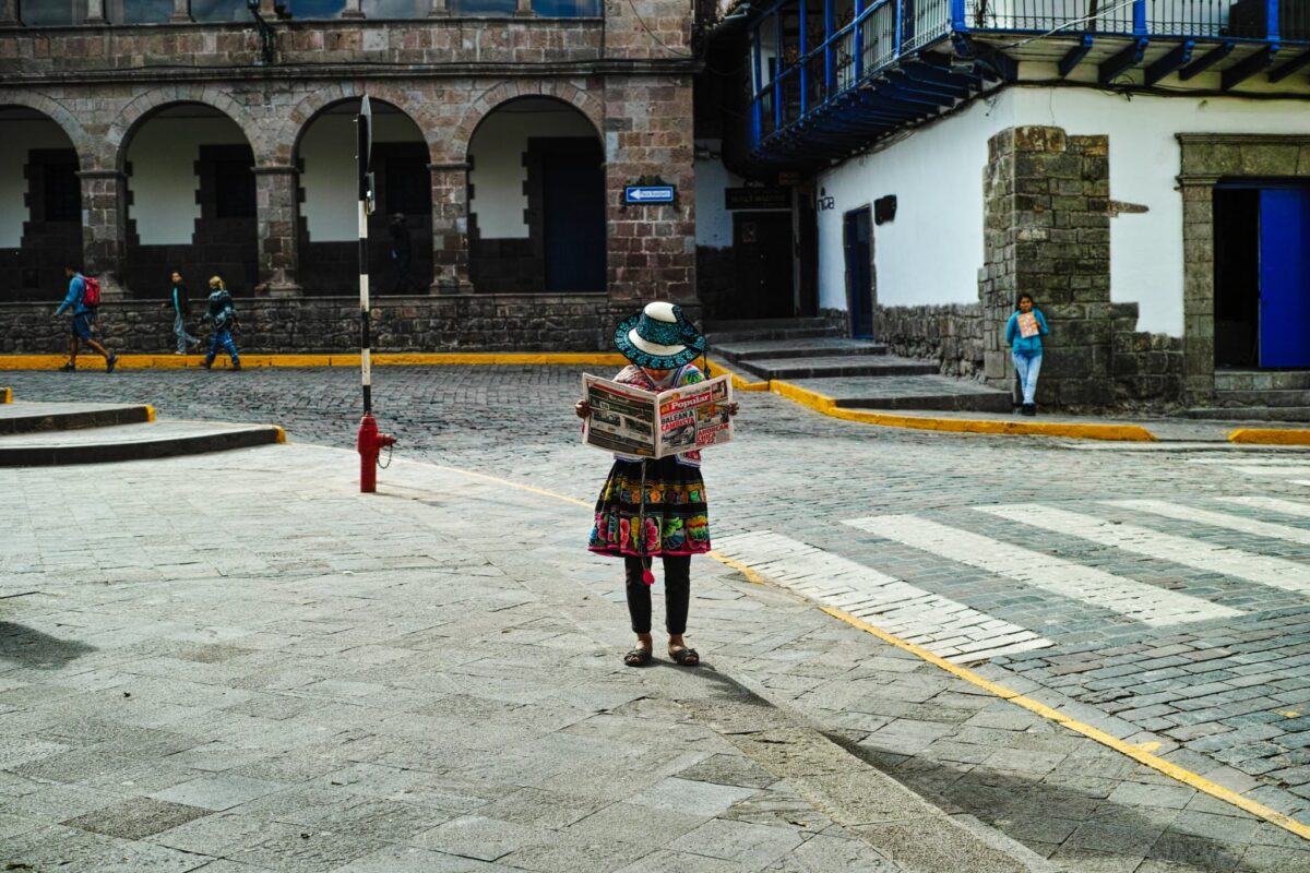 A person reading a book on a sidewalk